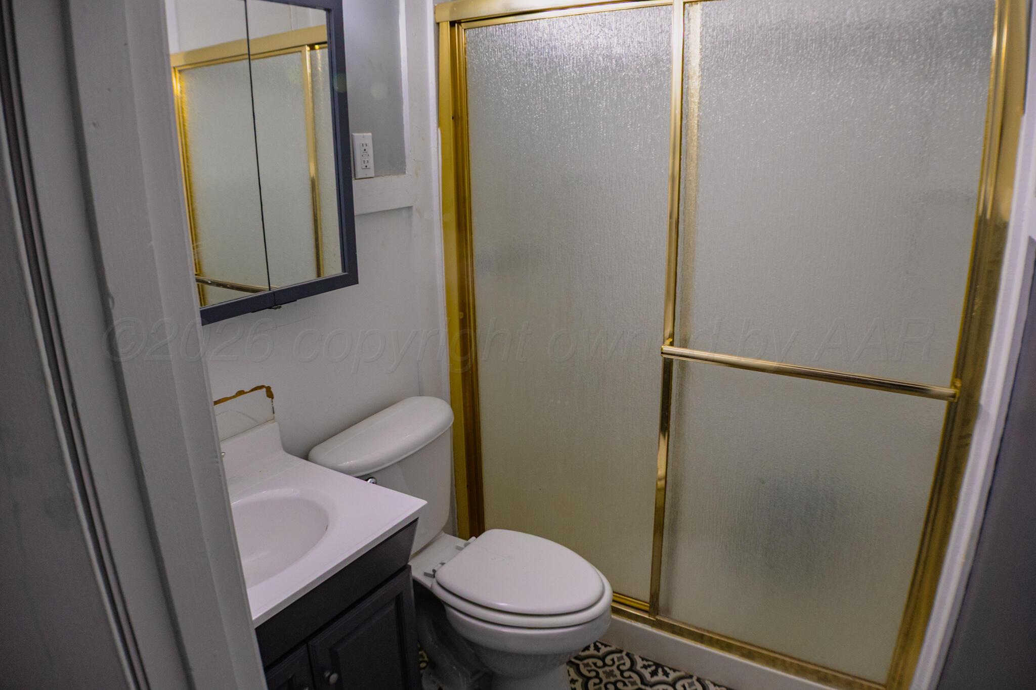 211 Butadieno Street Borger, TX 79007 - Photo 11 of 26 a bathroom with a granite countertop toilet and a sink