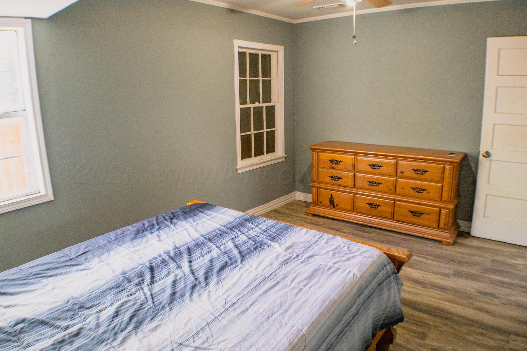 211 Butadieno Street Borger, TX 79007 - Photo 13 of 26 a bedroom with a bed and wooden floor