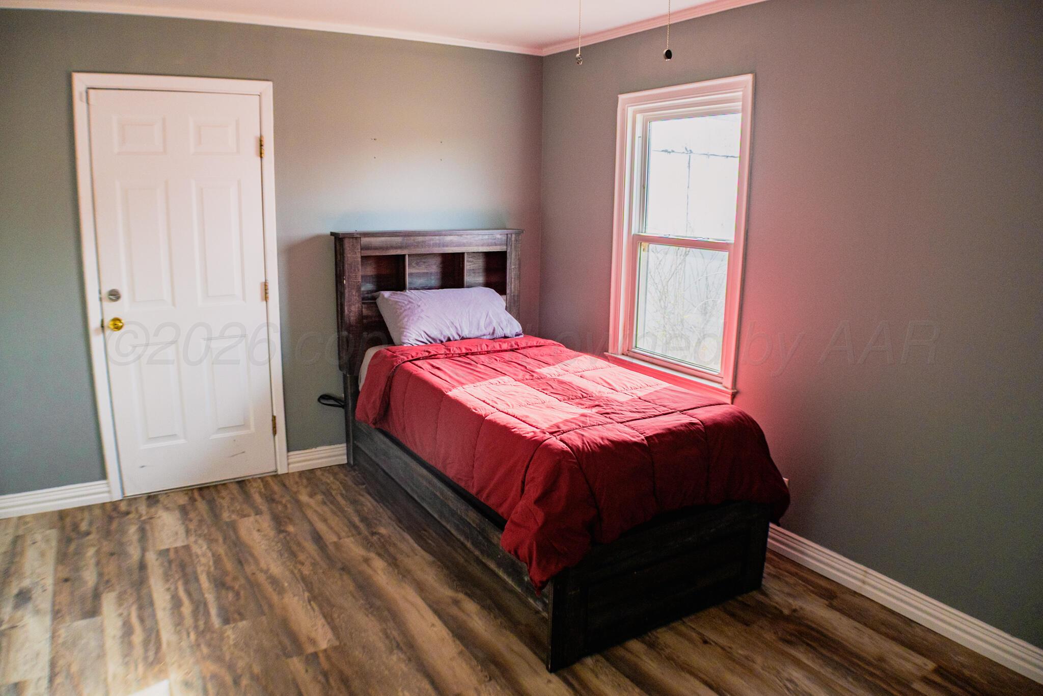 211 Butadieno Street Borger, TX 79007 - Photo 9 of 26 a bedroom with a bed and wooden floor
