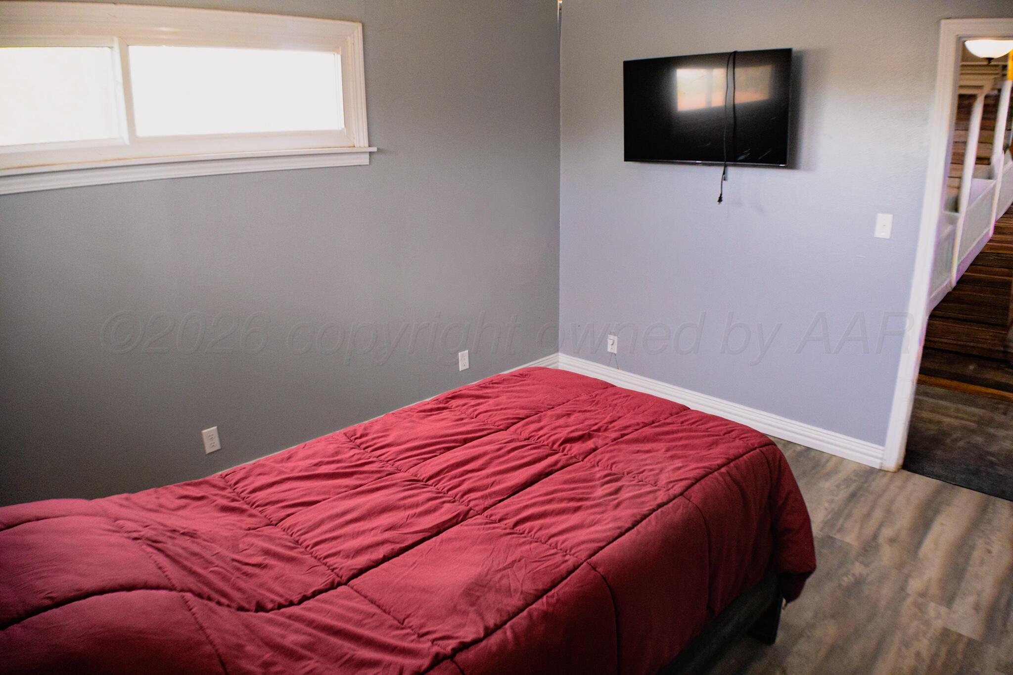 211 Butadieno Street Borger, TX 79007 - Photo 10 of 26 a bedroom with a bed and a flat screen tv