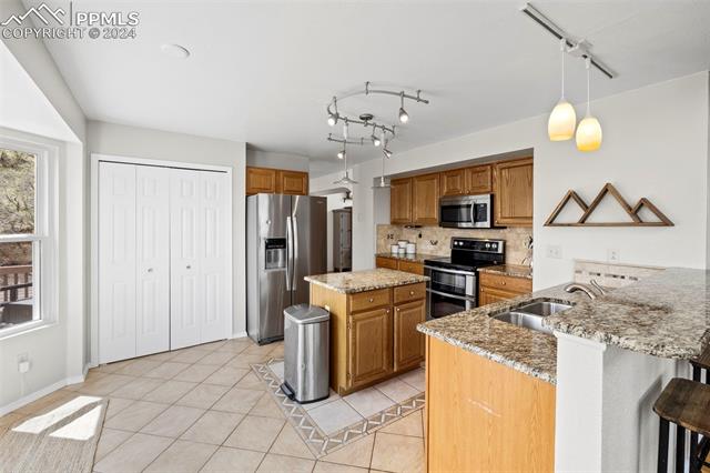 7850 Julynn Road Colorado Springs, CO 80919 - Photo 7 of 40 The kitchen features granite countertops and stainless steel appliances