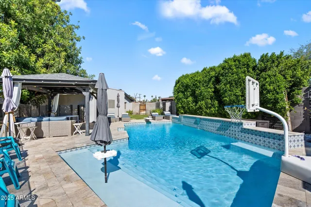a view of a swimming pool with a patio and plants