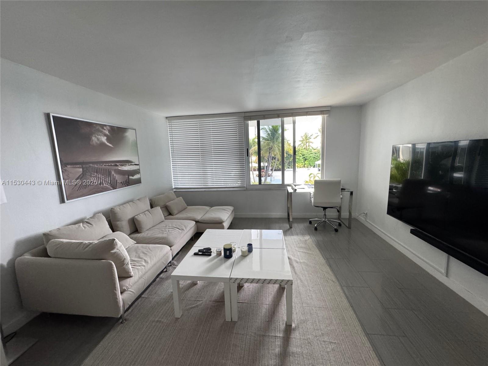 1200 West Avenue, Unit 202 Miami Beach, FL 33139 - Photo 1 of 45 a living room with furniture and a flat screen tv