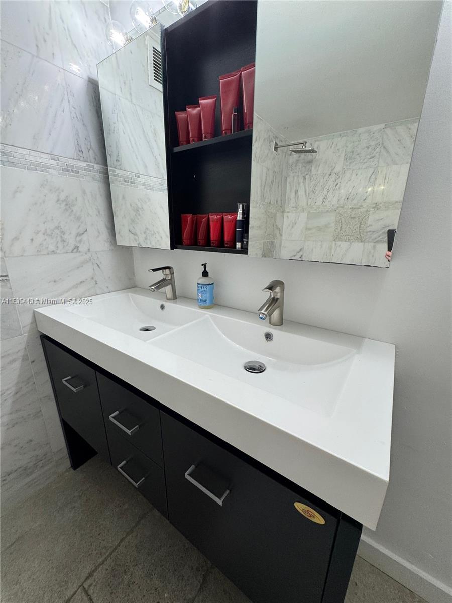 1200 West Avenue, Unit 202 Miami Beach, FL 33139 - Photo 8 of 45 a bathroom with a sink and a mirror