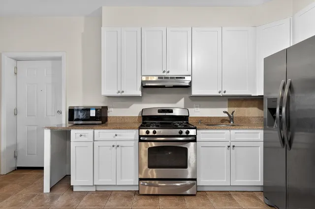a kitchen with white cabinets and stainless steel appliances