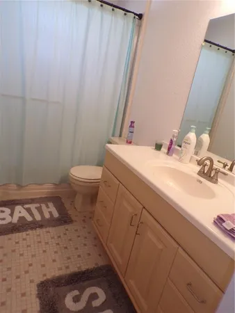 a bathroom with a sink a toilet and a mirror