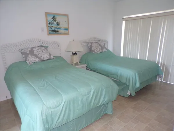 a bedroom with two beds and painting on the wall