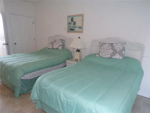 a bedroom with two beds and painting on the wall