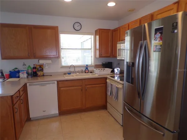 a kitchen with a refrigerator stove top oven and sink