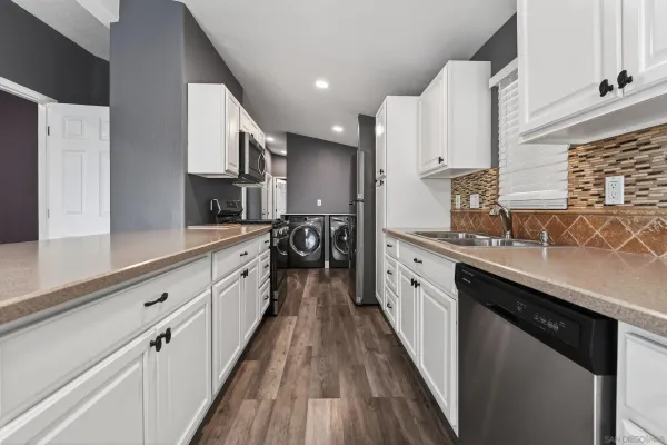 a large kitchen with stainless steel appliances sink a microwave and cabinets