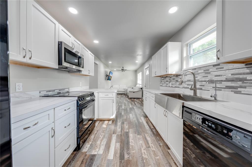 150 North Post Road Kenansville, FL 34739 - Photo 12 of 42 a large kitchen with stainless steel appliances granite countertop a lot of counter space and wooden floors