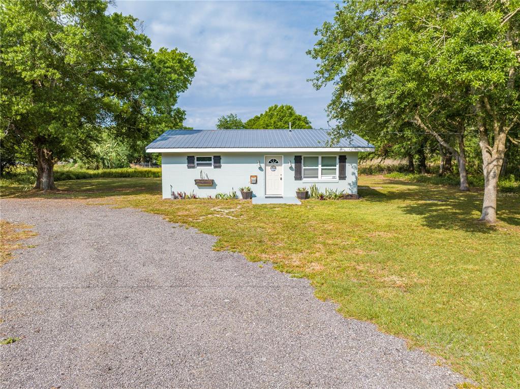 150 North Post Road Kenansville, FL 34739 - Photo 5 of 42 a view of a house with a yard and large tree