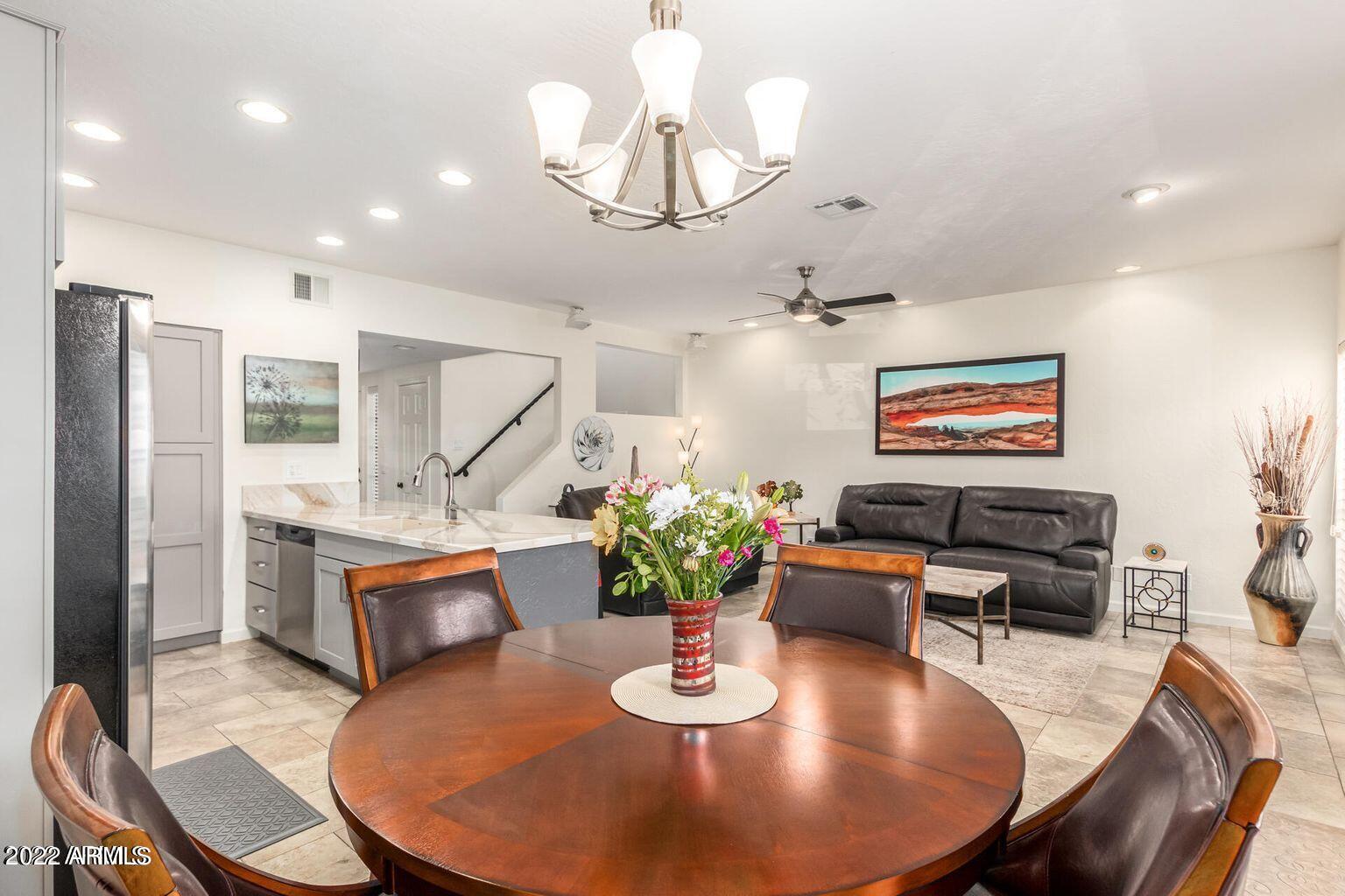 a dining room with furniture a chandelier and wooden floor