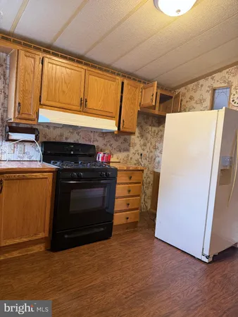 a kitchen with granite countertop a stove and a refrigerator