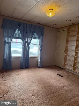 an empty room with windows and closet
