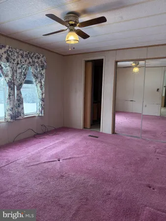 an empty room with windows and ceiling fan