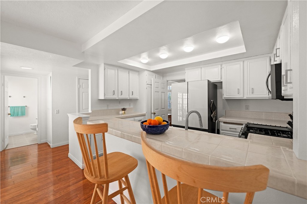 16 Wellesley, Unit 2 Irvine, CA 92612 - Photo 15 of 55 a kitchen with stainless steel appliances a sink a stove a refrigerator cabinets and dining table