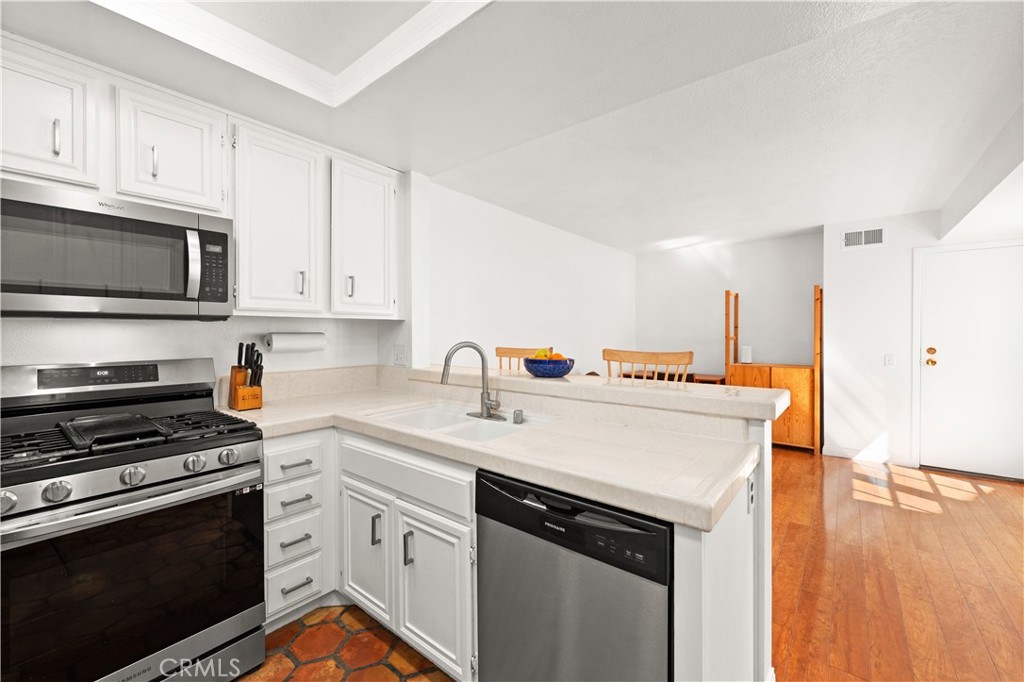 16 Wellesley, Unit 2 Irvine, CA 92612 - Photo 17 of 55 a kitchen with stainless steel appliances granite countertop a stove a sink and a microwave