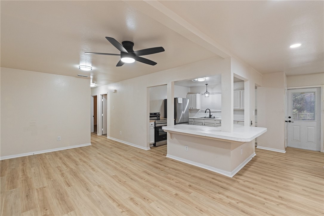 5921 Riley Drive Corpus Christi, TX 78412 - Photo 10 of 20 a view of a kitchen with kitchen island a sink wooden floor and a refrigerator