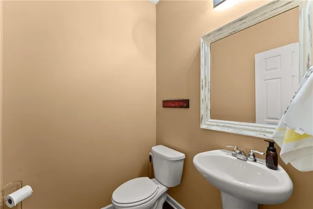 a bathroom with a toilet a sink and mirror