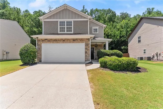 a front view of a house with a yard and garage