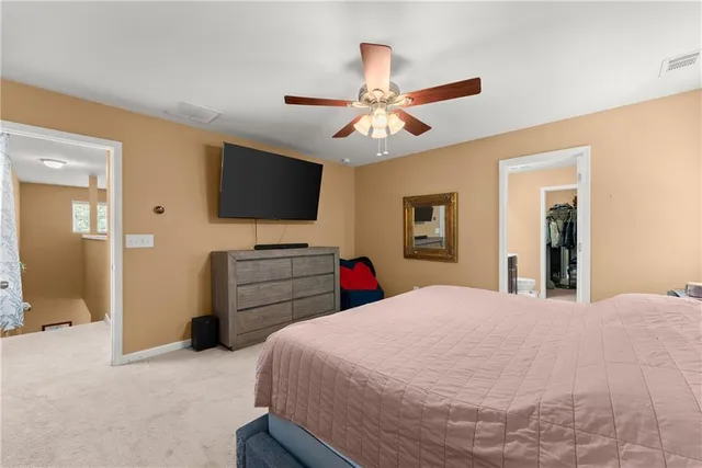 a bedroom with a bed and a flat tv screen on dresser