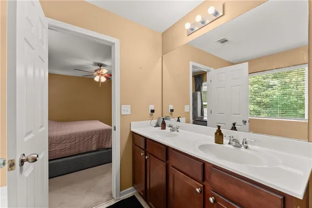 a en suite bathroom with a double vanity sink a mirror and a shower