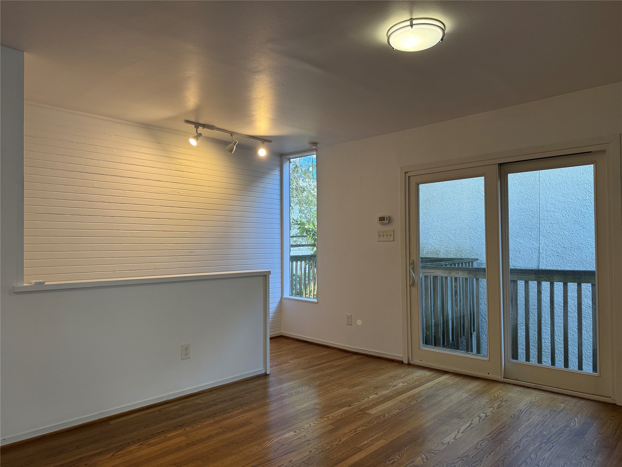2721 Kipling Street, Unit D Houston, TX 77098 - Photo 4 of 15 an empty room with wooden floor and windows