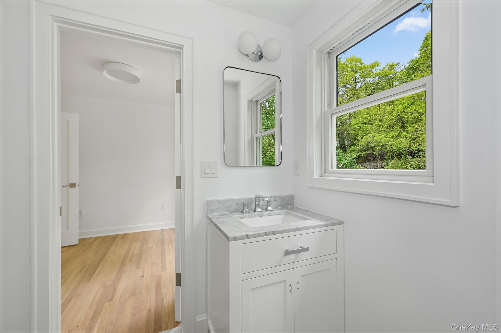 24 Country Road Mamaroneck, NY 10543 - Photo 23 of 37 a bathroom with a sink a vanity and a mirror