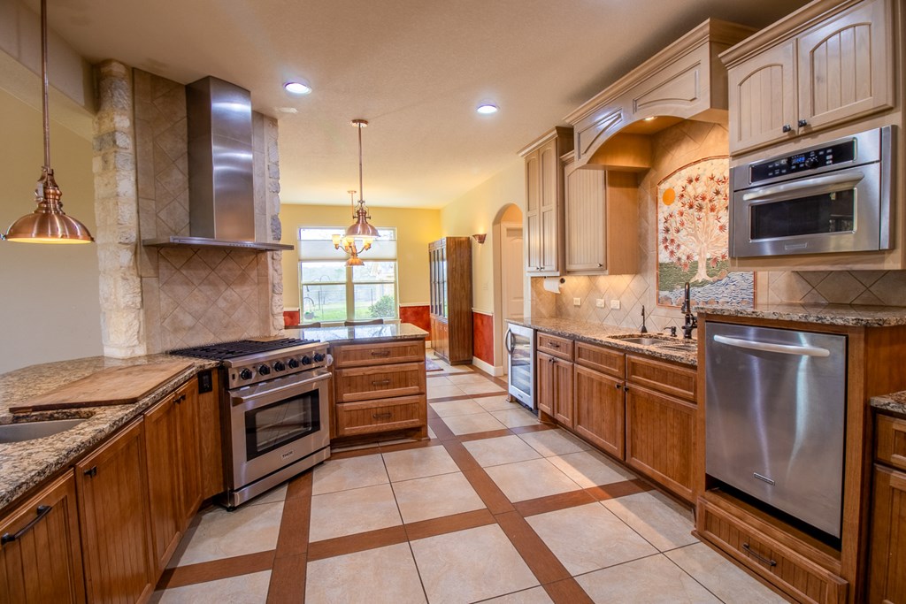 6515 Highway 27 Center Point, TX 78010 - Photo 12 of 48 a large kitchen with stainless steel appliances granite countertop a stove a sink and a microwave
