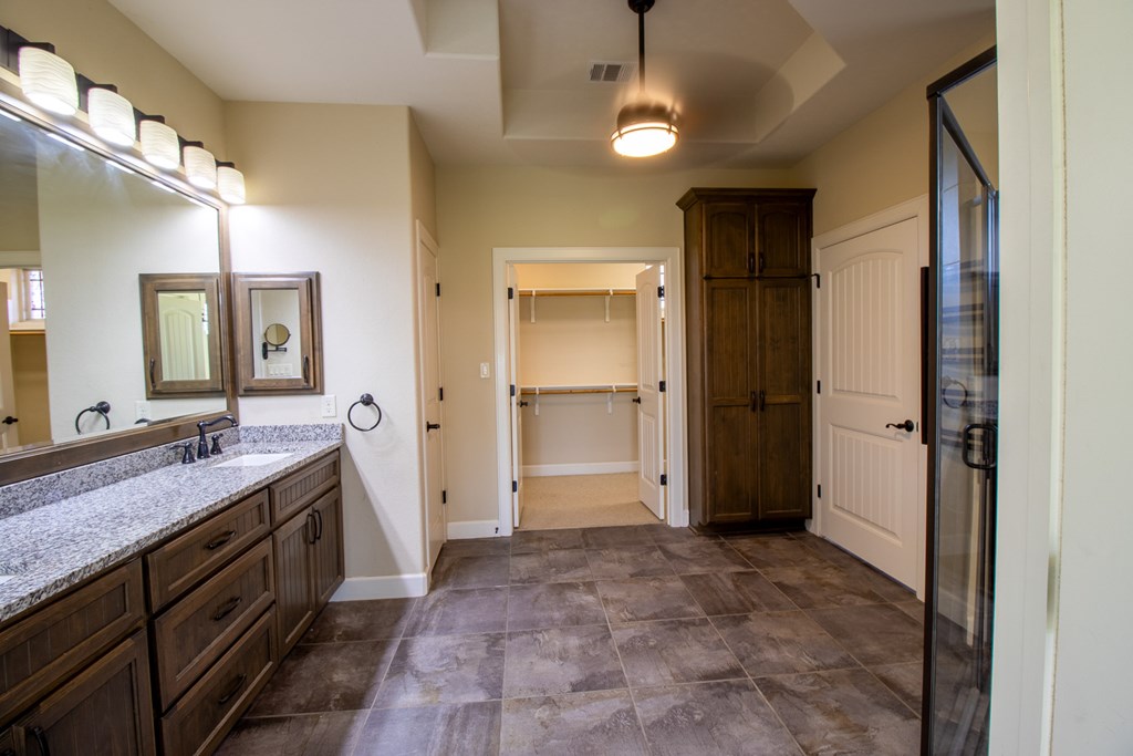 6515 Highway 27 Center Point, TX 78010 - Photo 16 of 48 a spacious bathroom with a granite countertop sink mirror and a shower