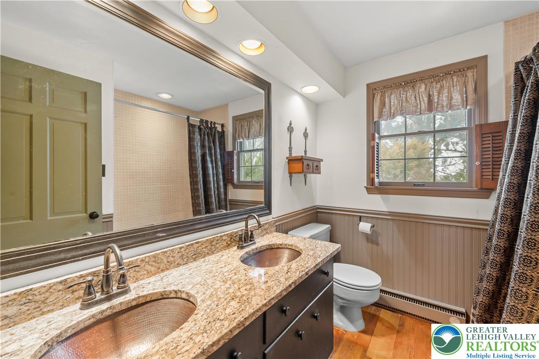 904 Parkway Road Allentown, PA 18104 - Photo 30 of 42 a bathroom with a granite countertop double vanity sink a mirror and a bathtub