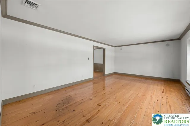 a view of an empty room and wooden floor