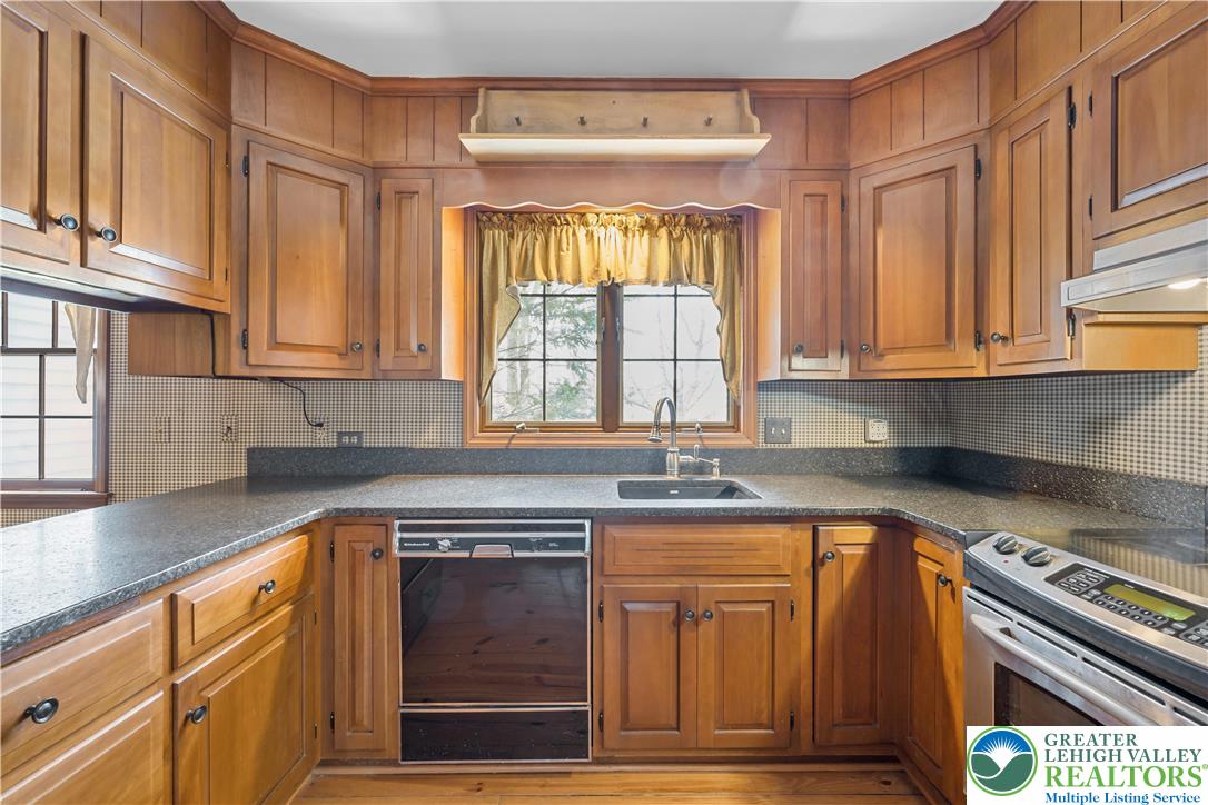 904 Parkway Road Allentown, PA 18104 - Photo 10 of 42 a kitchen with granite countertop a sink cabinets stainless steel appliances and a window