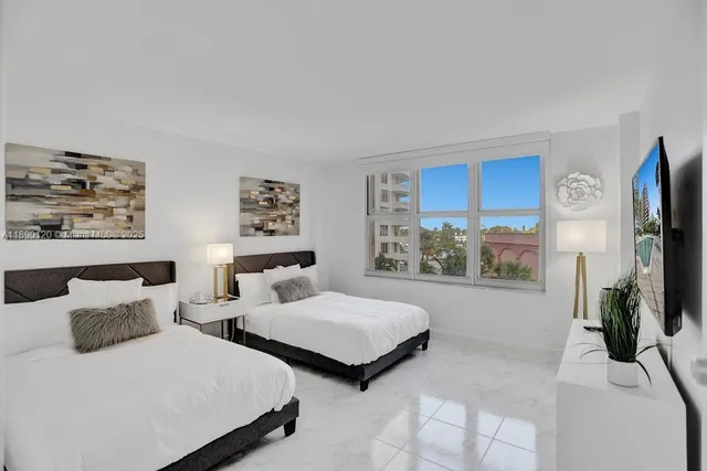 a bedroom with two beds and a flat screen tv