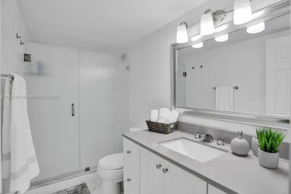 a bathroom with a granite countertop sink a toilet and a mirror