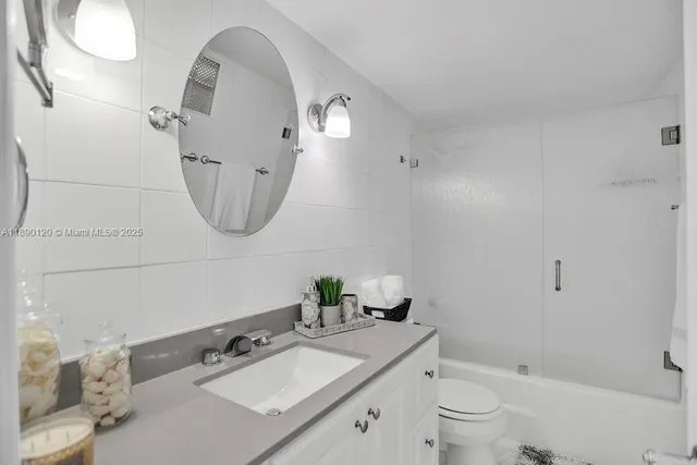 a bathroom with a toilet a sink a mirror and vanity