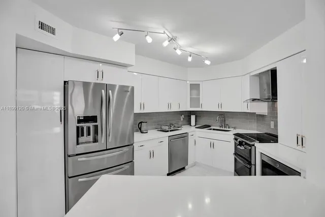 a kitchen with stainless steel appliances granite countertop a stove a refrigerator and a sink