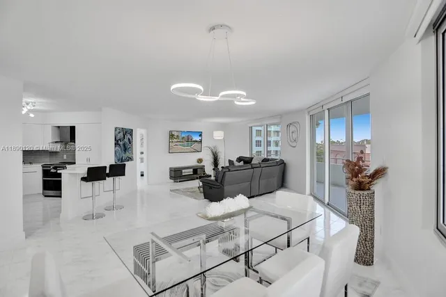 a living room with furniture a flat screen tv and kitchen view