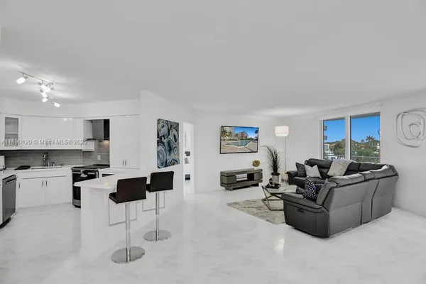 a living room with furniture and a kitchen view