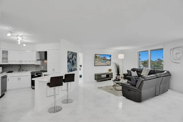 a living room with furniture and a kitchen view
