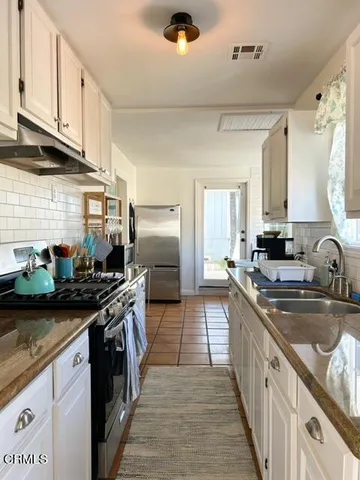 a kitchen with stainless steel appliances granite countertop a sink stove and cabinets