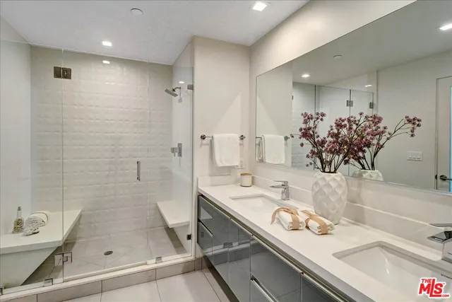 a bathroom with a sink mirror and shower