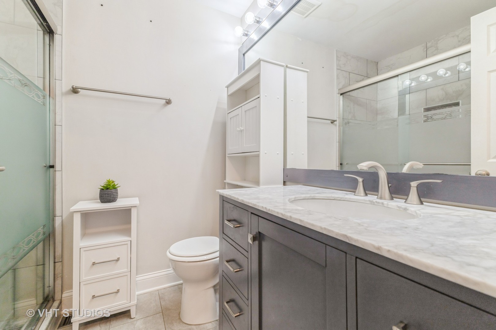 1328 South Federal Street, Unit G Chicago, IL 60605 - Photo 18 of 27 a bathroom with a granite countertop sink a toilet and a mirror