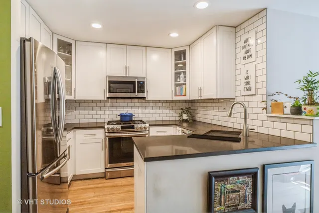 a kitchen with stainless steel appliances granite countertop a stove a sink and a refrigerator