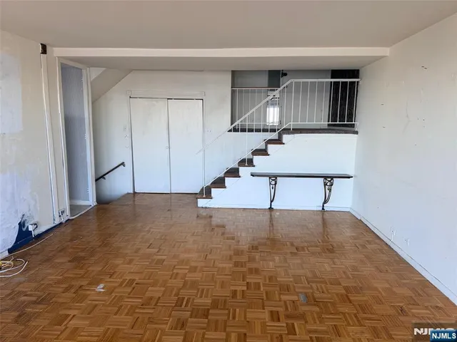 a view of a livingroom with wooden floor and white walls