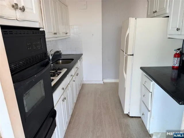 a kitchen with a sink a refrigerator and cabinets