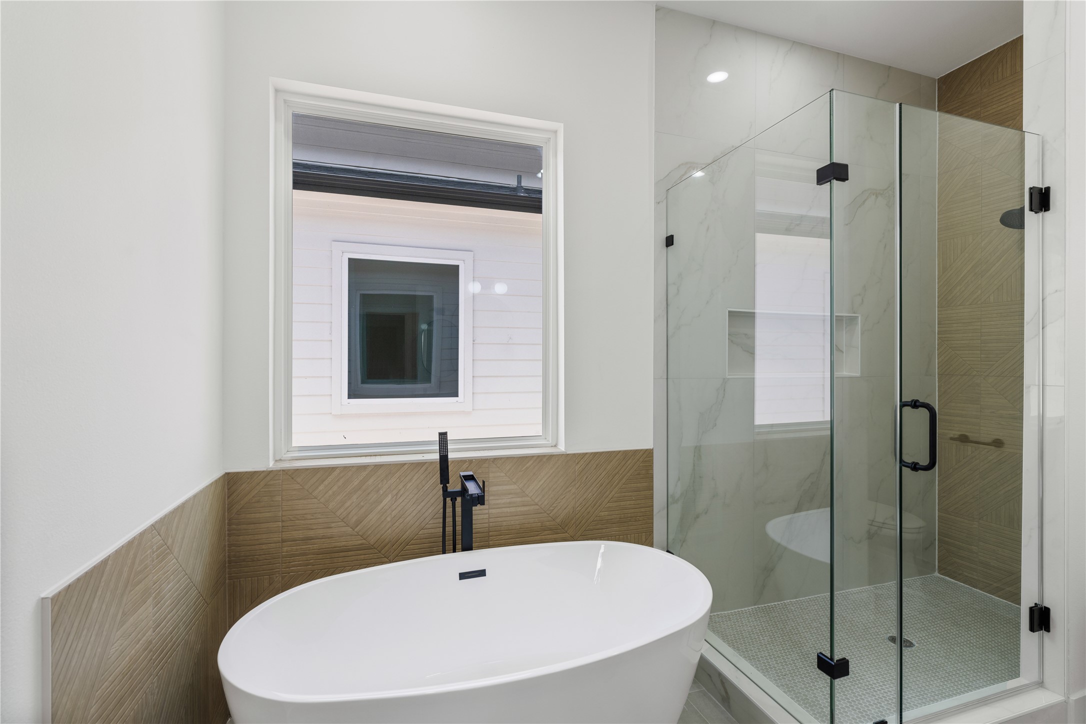 7321 Laura Koppe Road Houston, TX 77028 - Photo 30 of 35 Experience modern elegance in this bathroom featuring a luxurious freestanding tub, a sleek glass-enclosed shower, and stylish tile accents.