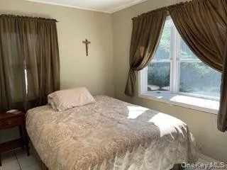 a bedroom with a bed lamp and a large window