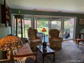 a living room with furniture and a floor to ceiling window